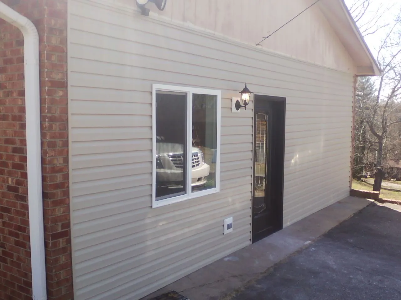 New vinyl siding and entry door on a room addition in Jasper